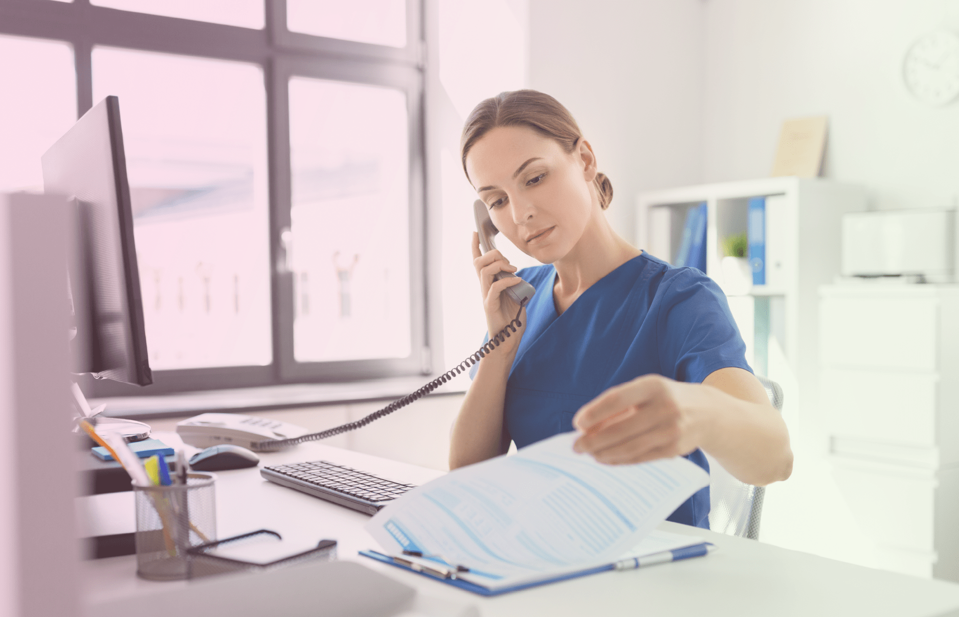 Nurse checking notes and paperwork while on the phone