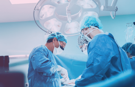 Doctor and surgeon working on patient hidden by a privacy sheet screen